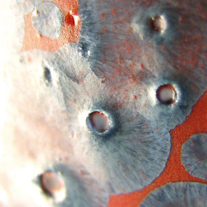 gla&ccedil;ure cristalline rouge bull&eacute;e par l'air de retrait du tesson de porcelaine (fort retrait de 12 &agrave; 14%)